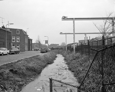 851694 Gezicht op de zwaar vervuilde sloot langs de 2e Daalsedijk te Utrecht, ter hoogte van de Papaverstraat. Rechts ...